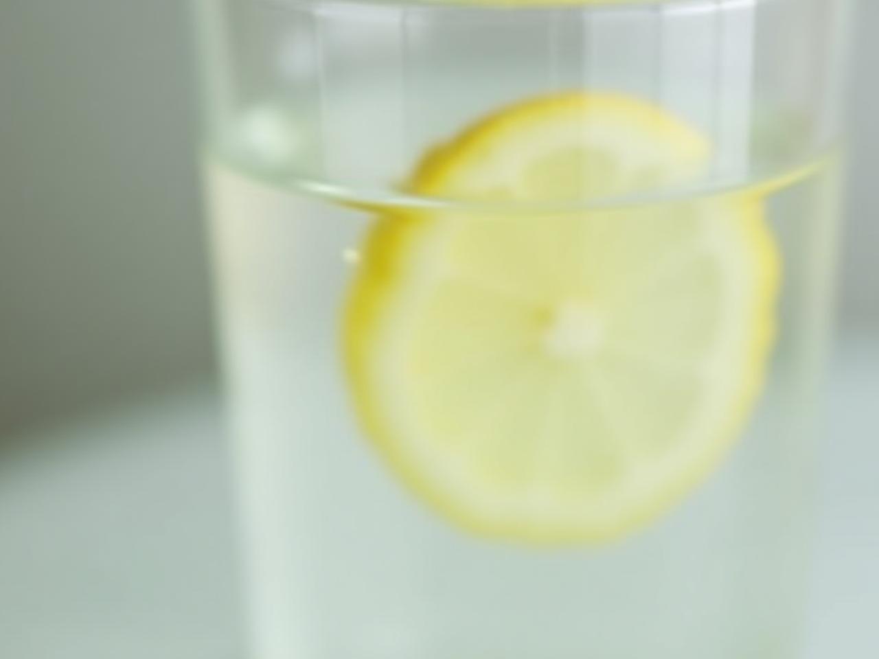 A glass of water with a lemon slice, symbolizing the purity and simplicity of a water fast.