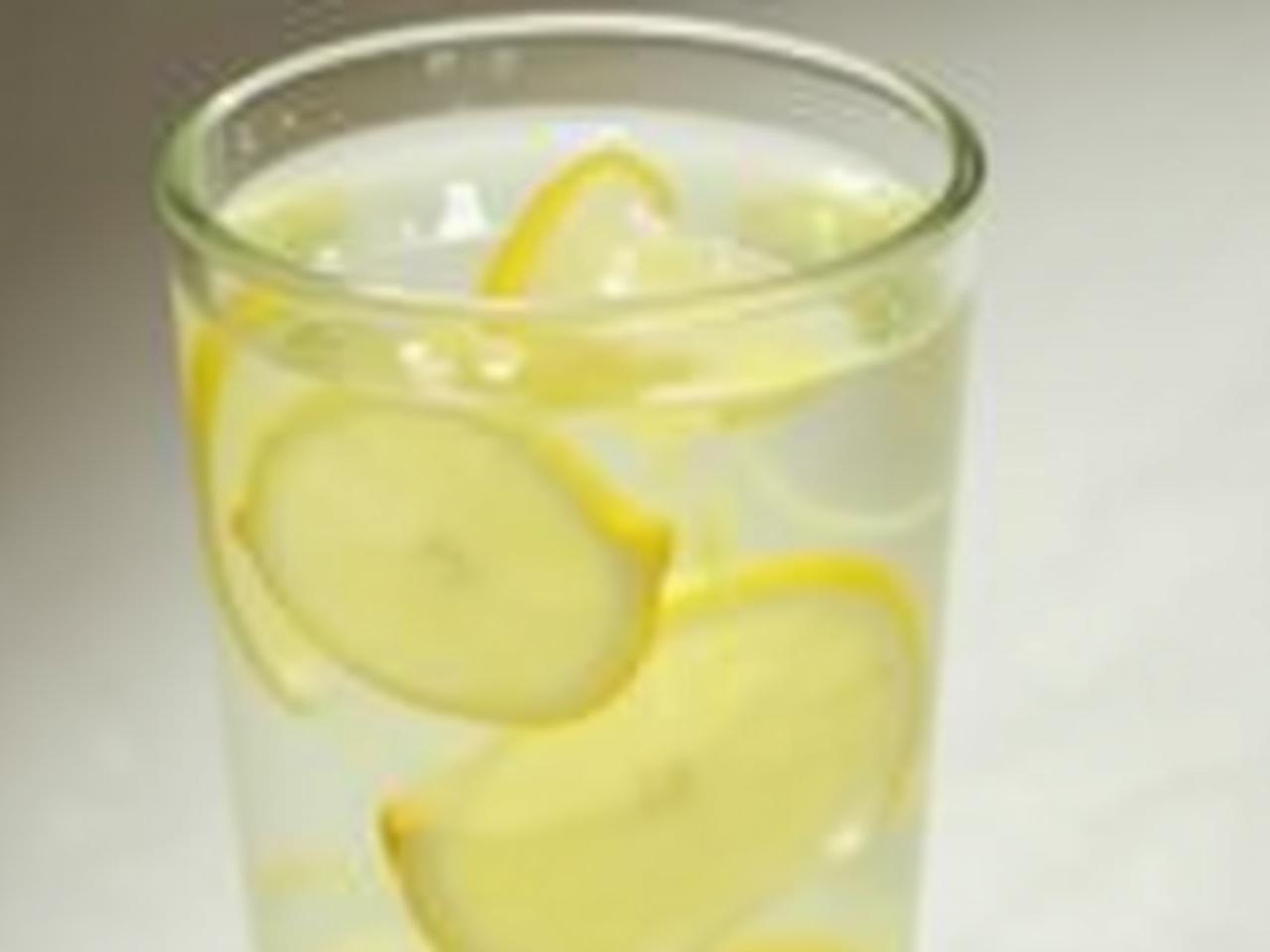 A glass of water with lemon slices, symbolizing hydration and anti-aging benefits.