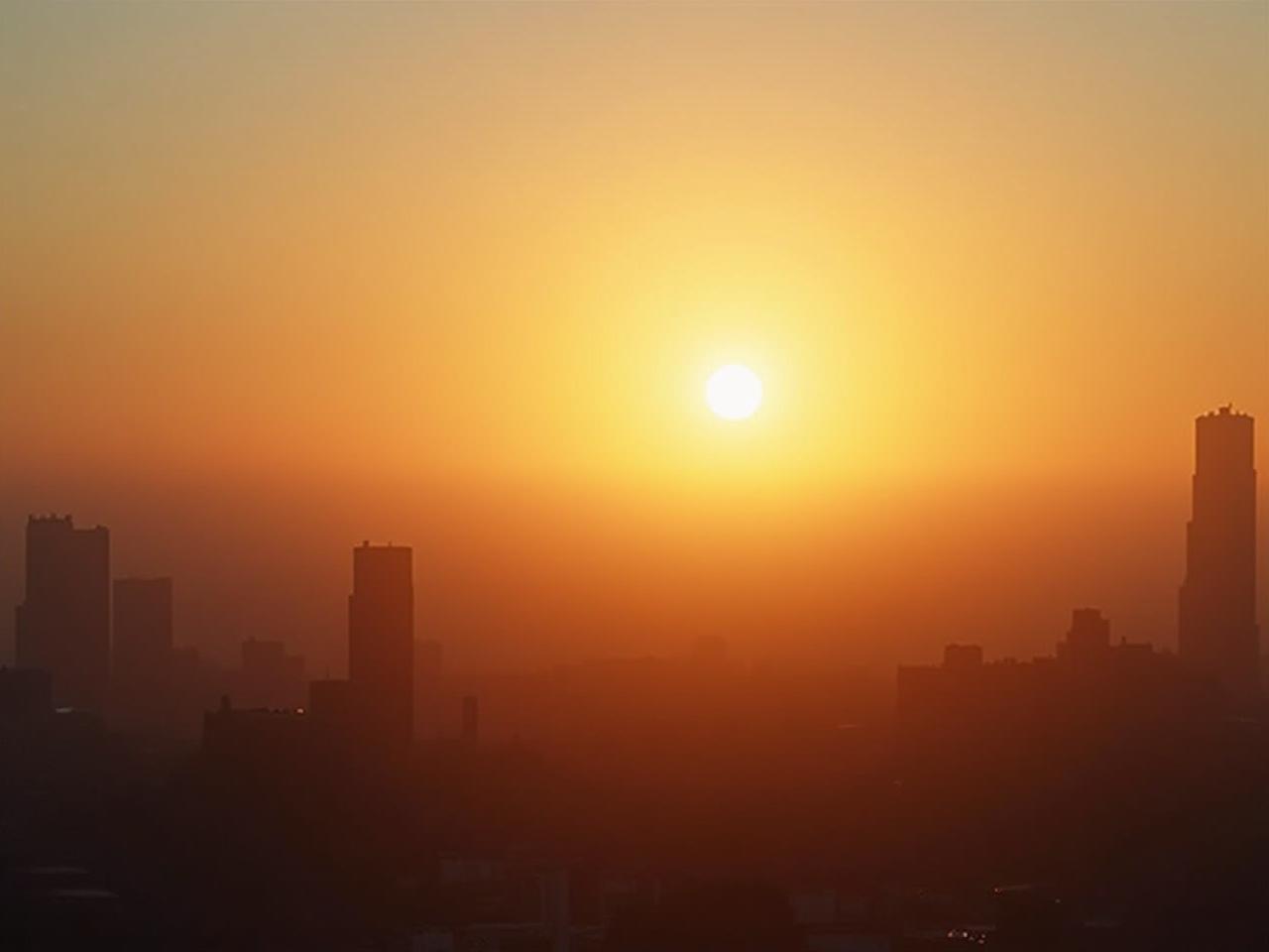 Sunrise over a cityscape, emphasizing the importance of morning light for serotonin production and sleep regulation.
